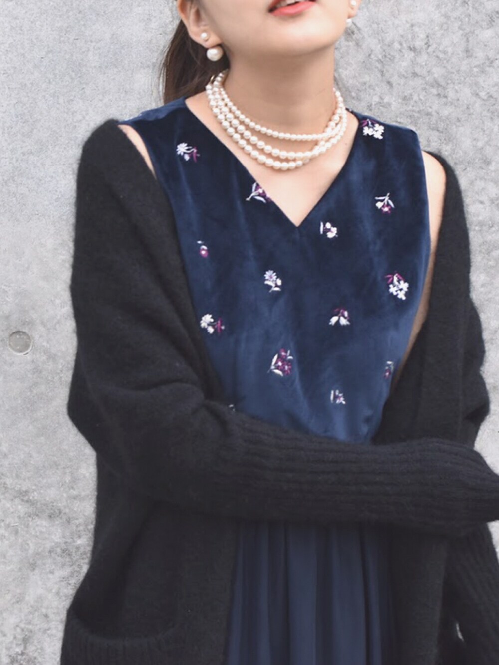 ブラック系のカーディガン/ボレロ、ブルー系のドレスを着用したレディースの冬コーディネートの1枚目の写真