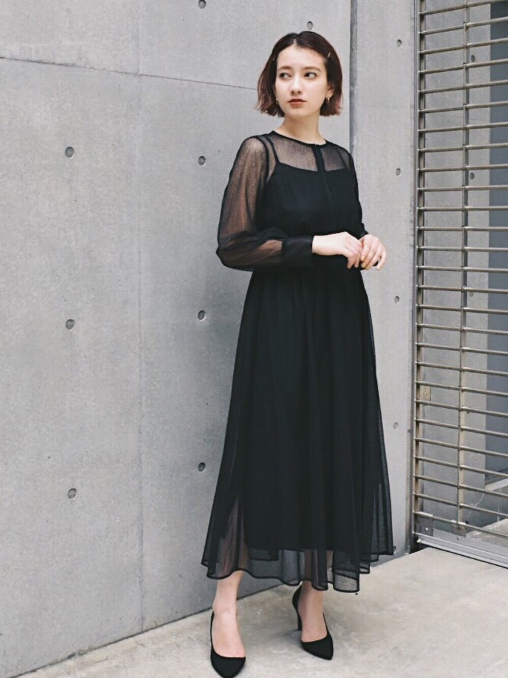 ブラック系のドレスを着用したレディースの冬コーディネートの1枚目の写真