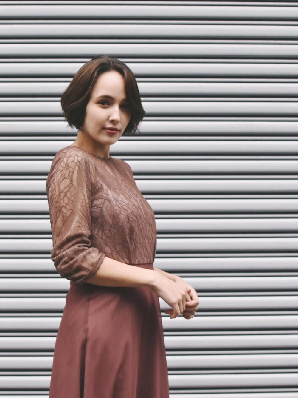 ブラウン系のドレスを着用したレディースの春コーディネートの1枚目の写真