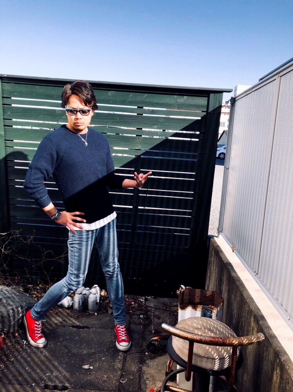 レッド系のスニーカー、ブルー系のデニムパンツ、シルバー系のアナログ腕時計を着用したメンズの冬コーディネートの1枚目の写真