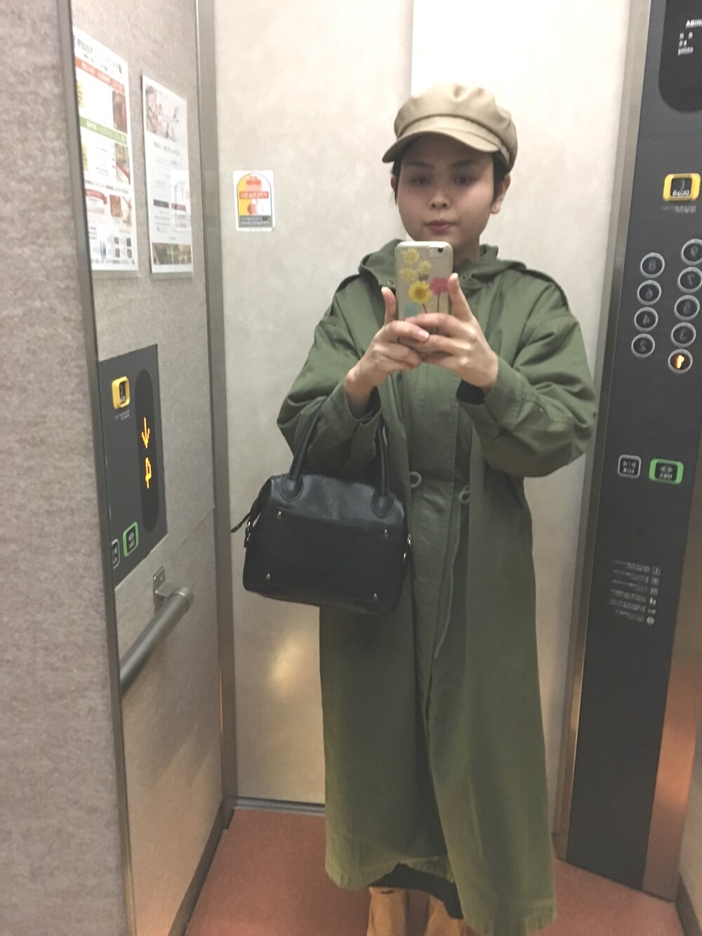 グリーン系のその他アウター、ブラック系のボストンバッグ、ベージュ系のキャスケットを着用したレディースの冬コーディネートの1枚目の写真