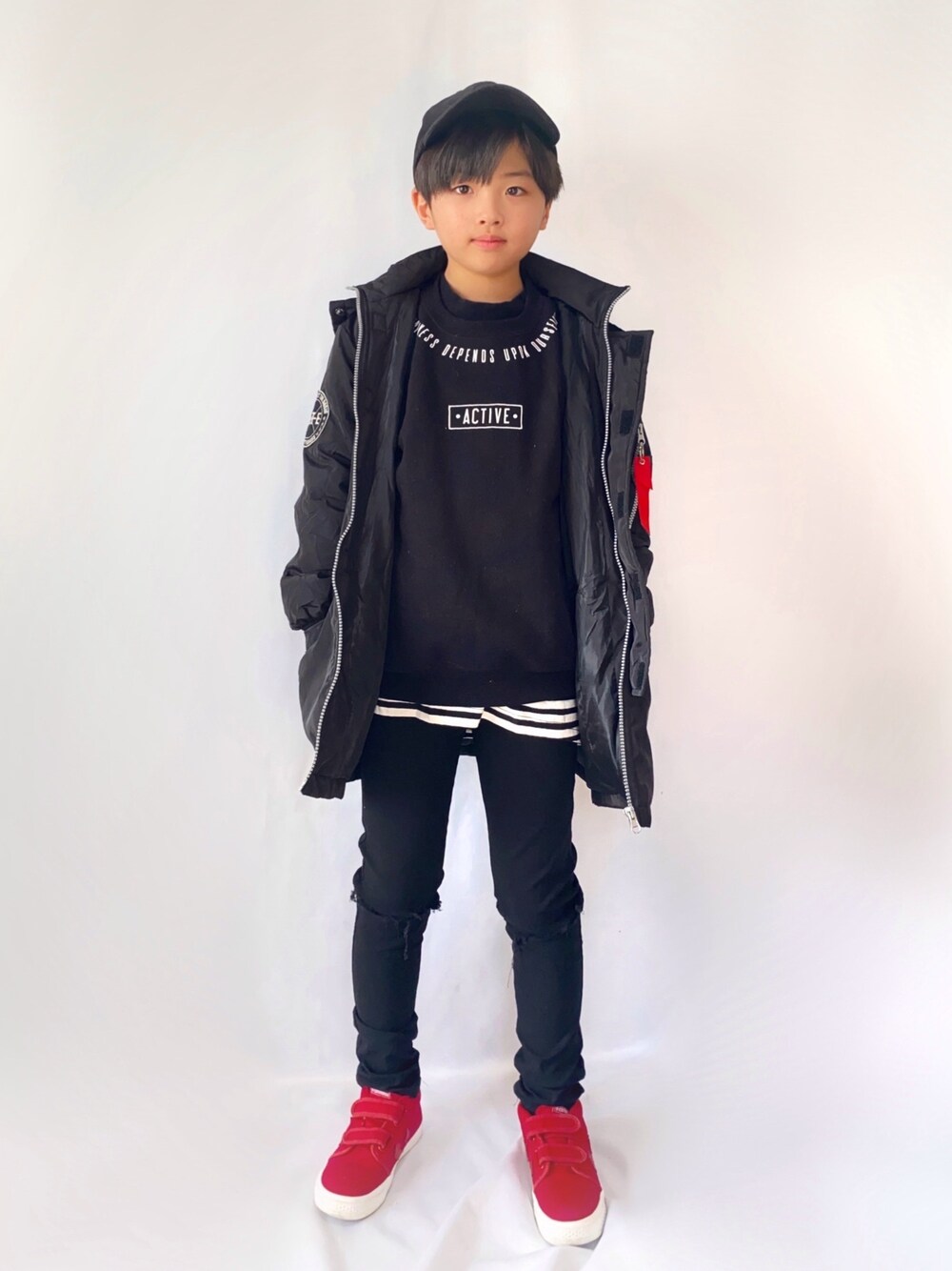 ブラック系のダウンジャケット/コート、ブラック系のTシャツ/カットソー、レッド系のスニーカーを着用したキッズの冬コーディネートの1枚目の写真