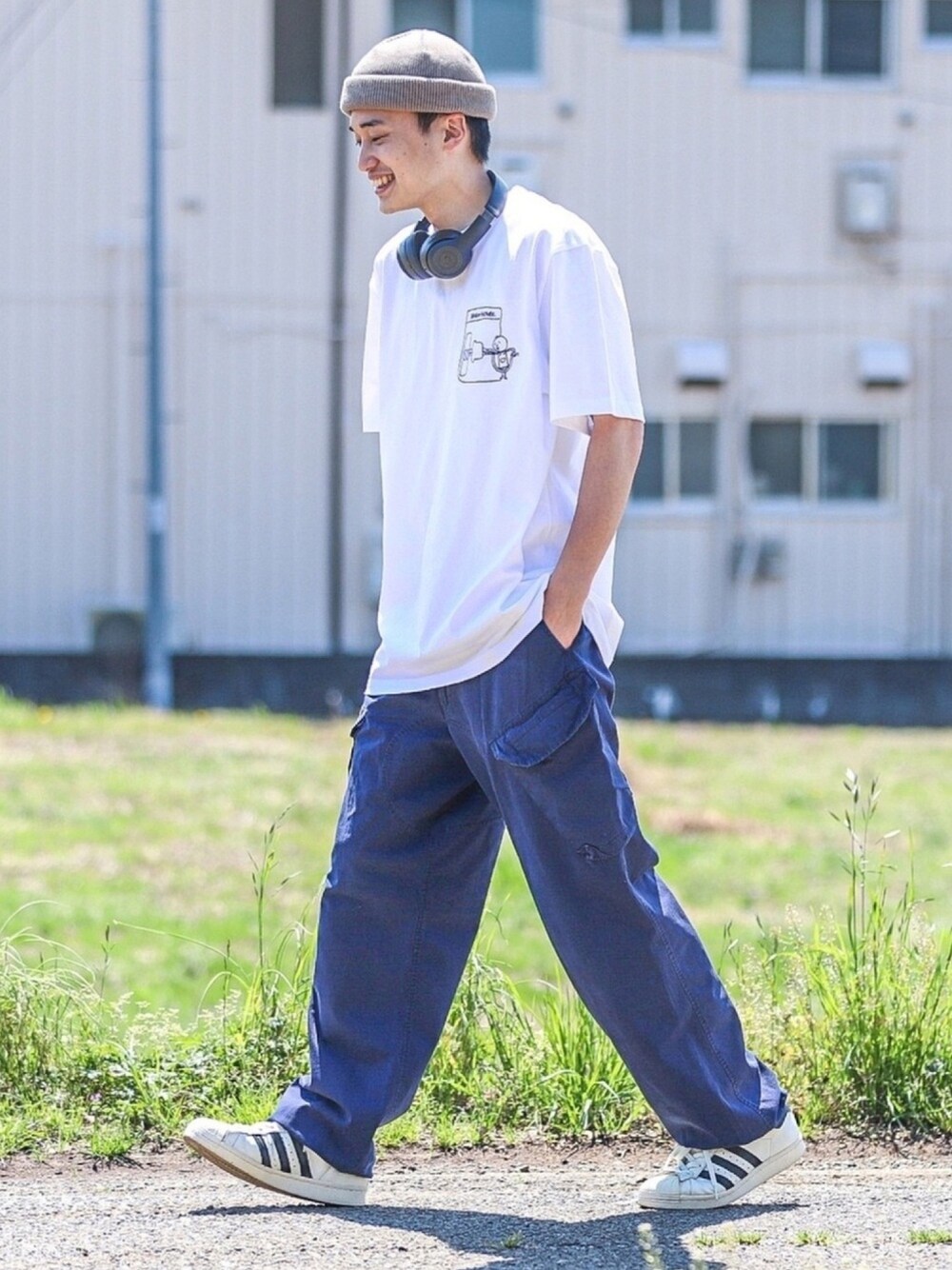 ブルー系のカーゴパンツ、ホワイト系のスニーカー、ホワイト系のTシャツ/カットソーを着用したメンズの春コーディネートの1枚目の写真