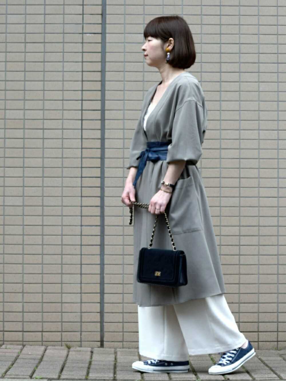 グリーン系のカーディガン/ボレロ、ブルー系のスニーカー、ホワイト系のその他パンツを着用したレディースの春コーディネートの1枚目の写真