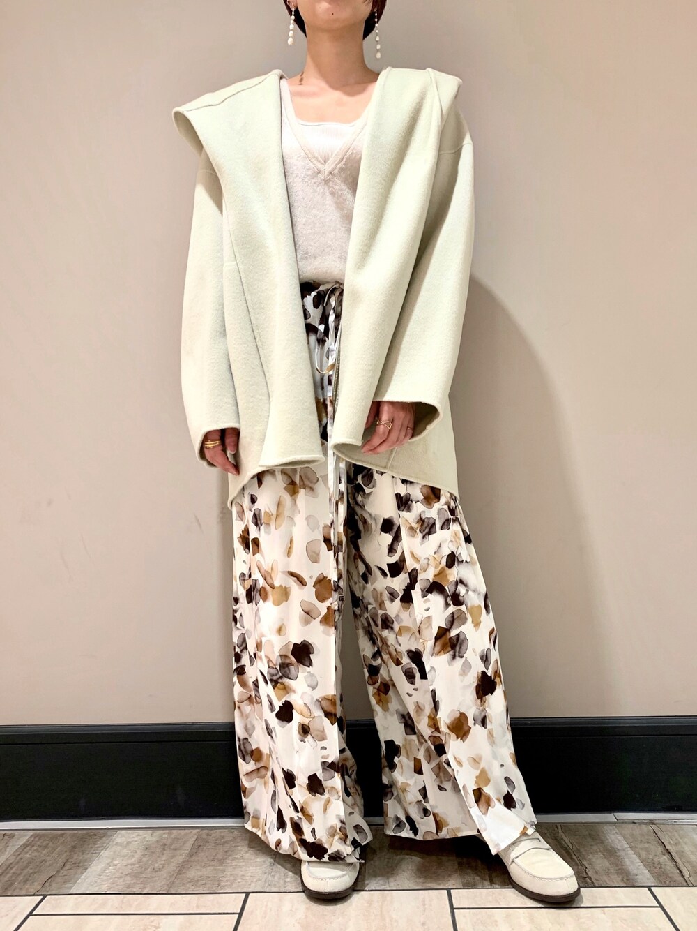 グリーン系のその他アウター、ホワイト系のその他パンツ、グレー系のニット/セーターを着用したレディースの秋コーディネートの1枚目の写真