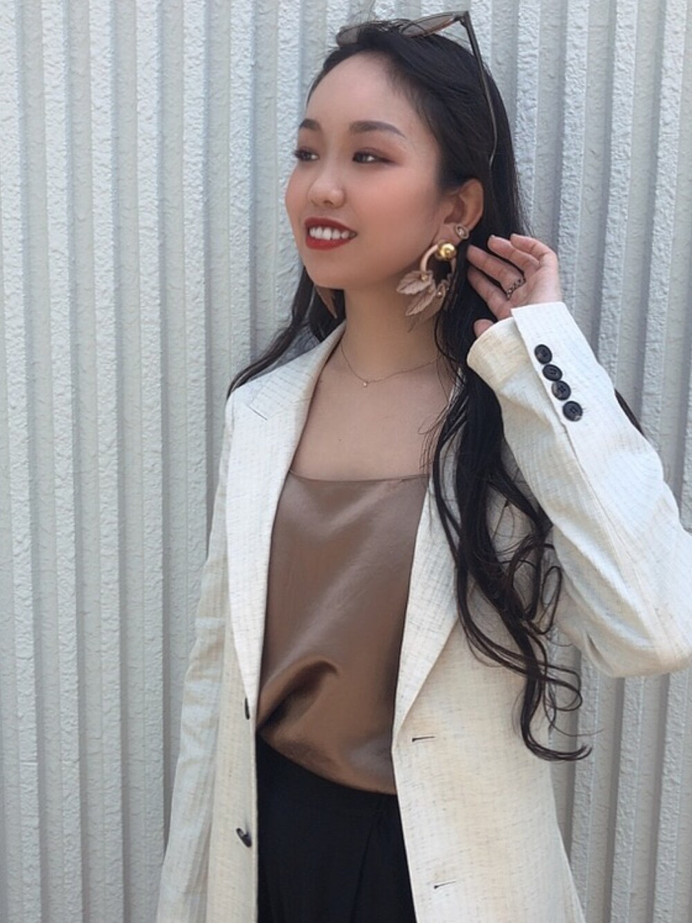 ゴールド系のイヤリングを着用したレディースの春コーディネートの1枚目の写真