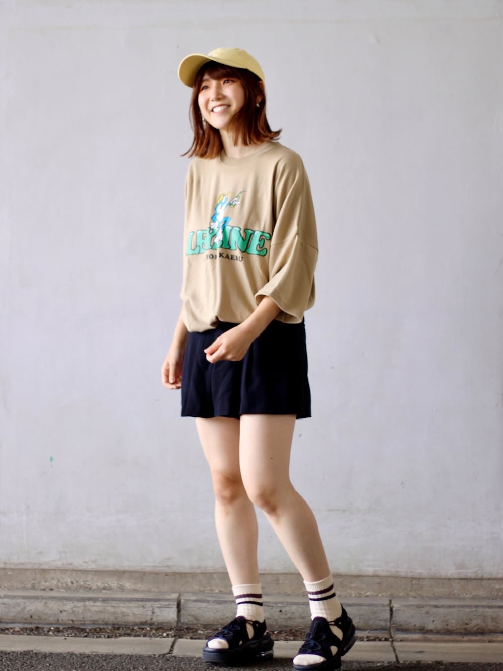 ベージュ系のTシャツ/カットソー、ブラック系のパンツ、ブラック系のサンダルを着用したレディースの春コーディネートの1枚目の写真