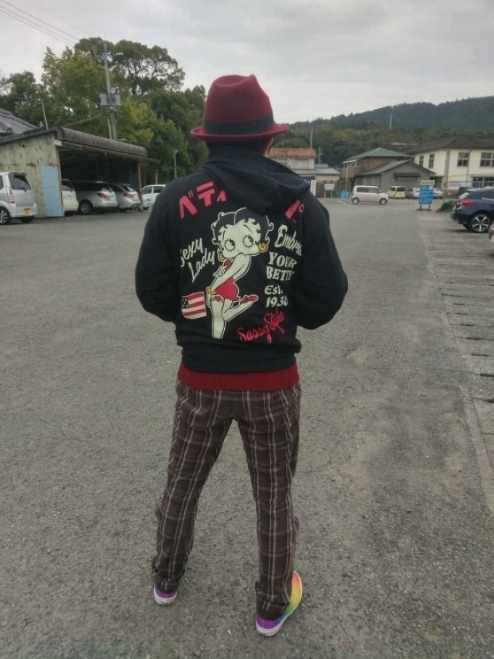 ブラウン系のチノパンツ、その他のスニーカー、ブラック系のパーカーを着用したメンズの冬コーディネートの1枚目の写真