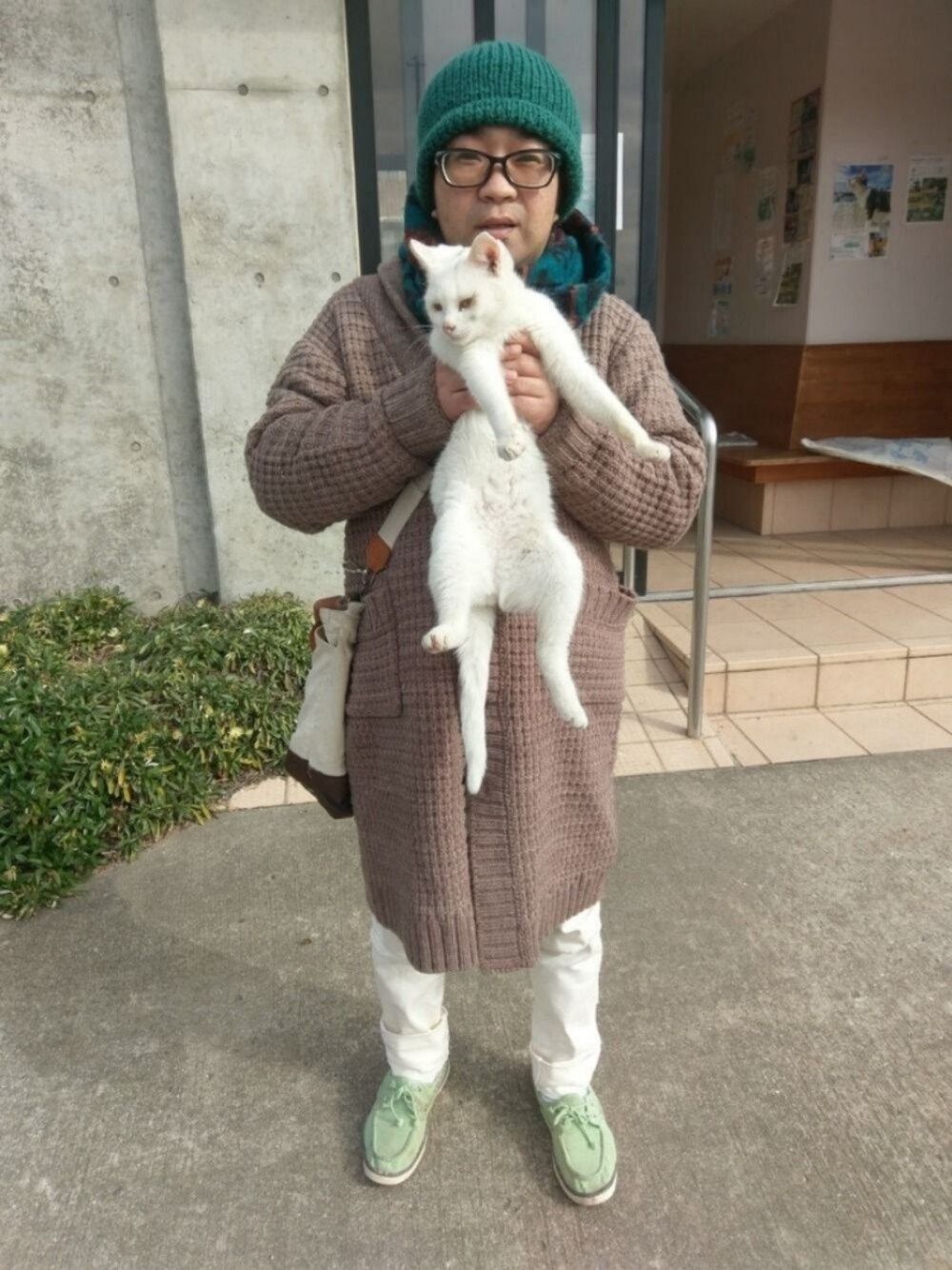 ホワイト系のデニムパンツ、グリーン系のモカシン/デッキシューズ、グリーン系のニットキャップ/ビーニーを着用したメンズの冬コーディネートの1枚目の写真