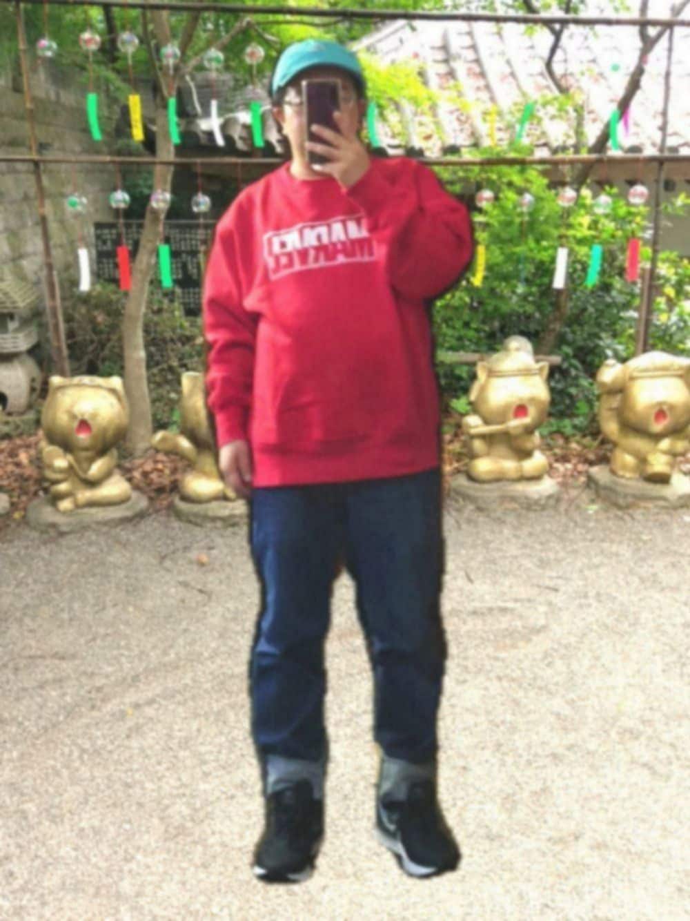 ブラック系のスニーカー、ブルー系のデニムパンツ、レッド系のスウェットを着用したメンズの春コーディネートの1枚目の写真