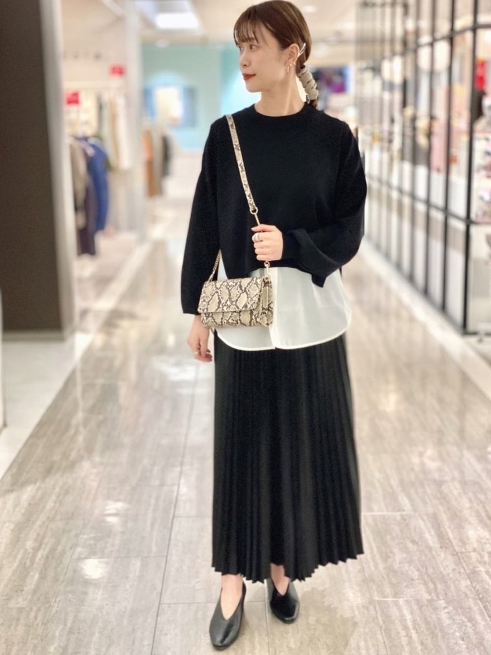 ブラック系のニット/セーター、ブラック系のパンプス、ブラック系のスカートを着用したレディースの夏コーディネートの1枚目の写真