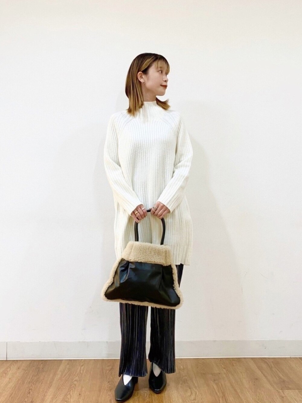 ホワイト系のニット/セーター、ブラック系のトートバッグ、ブルー系のその他パンツを着用したレディースの秋コーディネートの1枚目の写真