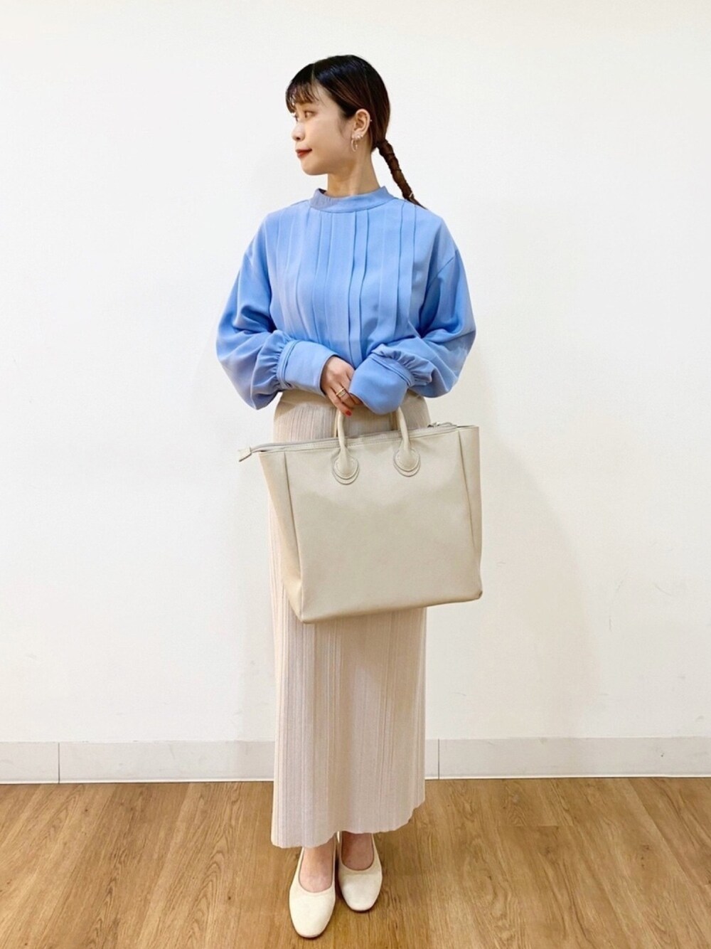 ブルー系のシャツ/ブラウス、ベージュ系のショルダーバッグ、ホワイト系のパンプスを着用したレディースの春コーディネートの1枚目の写真