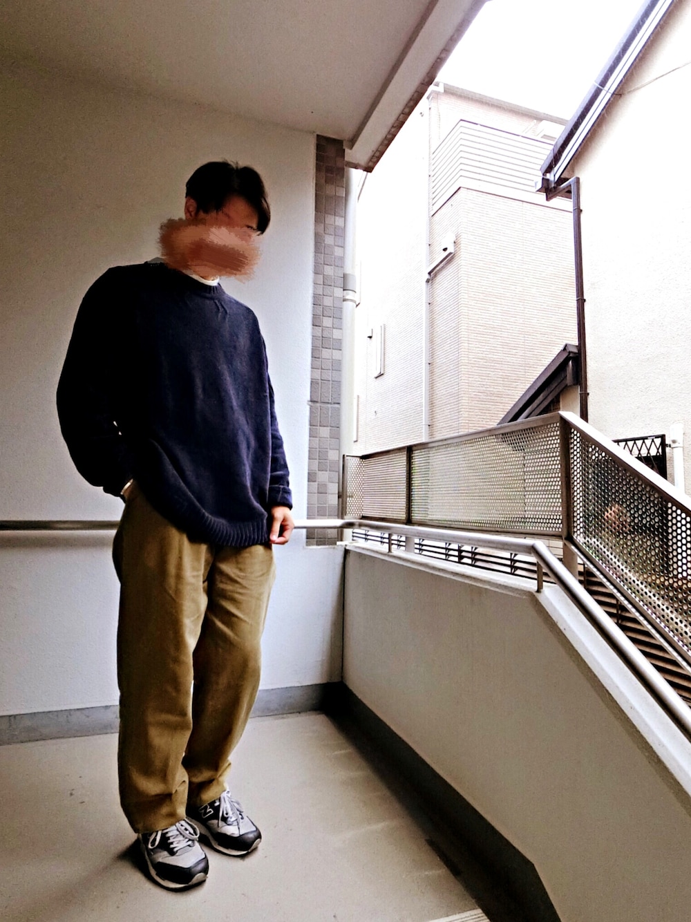 ブルー系のニット/セーター、ホワイト系のTシャツ/カットソー、ベージュ系のチノパンツを着用したメンズの春コーディネートの1枚目の写真