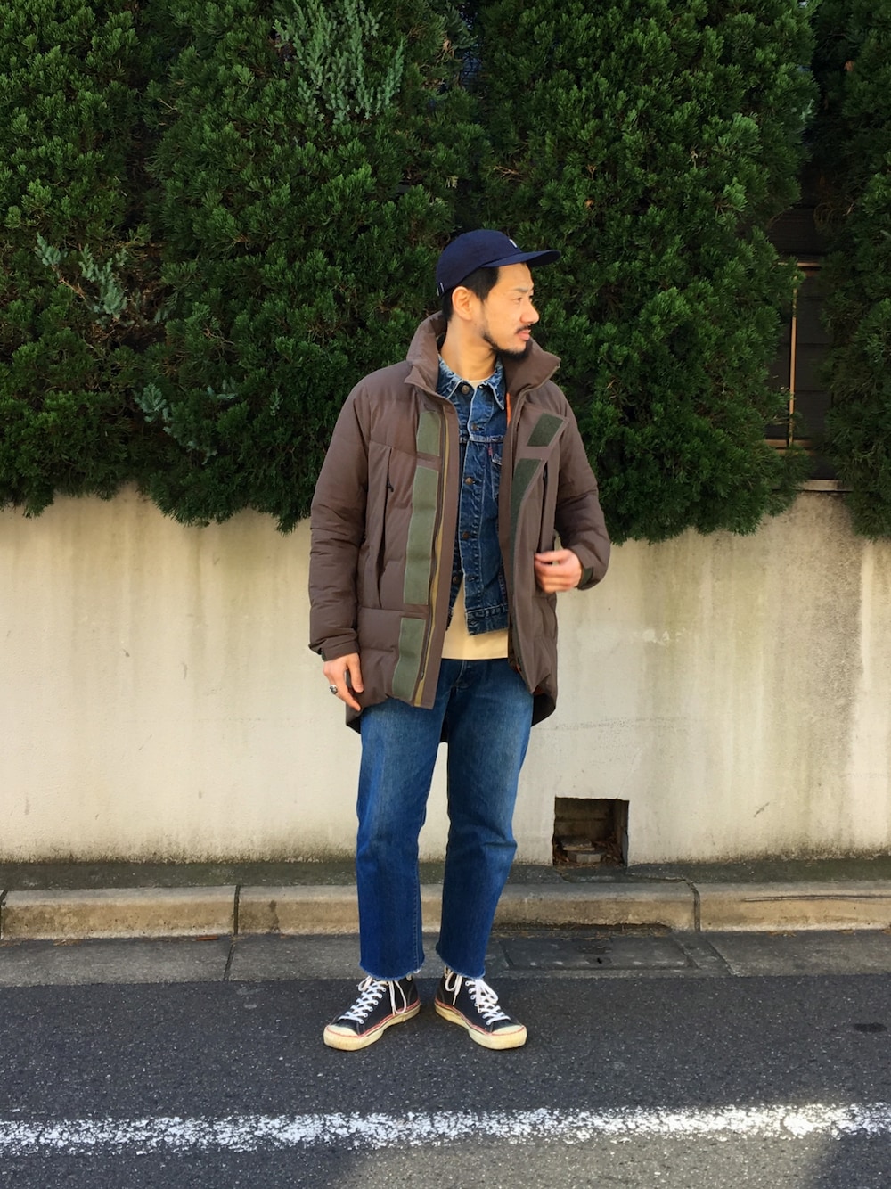 ホワイト系のTシャツ/カットソー、グリーン系のダウンジャケット/コート、ブラック系のスニーカーを着用したメンズの冬コーディネートの1枚目の写真