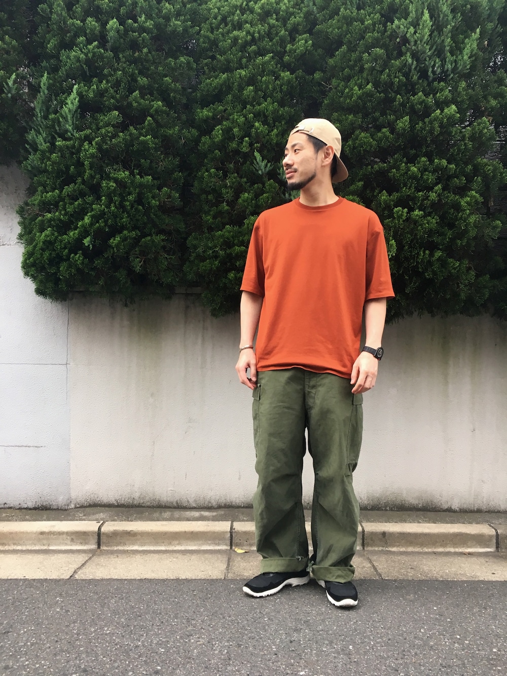 ブラウン系のTシャツ/カットソー、ブラック系のスニーカー、グリーン系のその他パンツを着用したメンズの春コーディネートの1枚目の写真