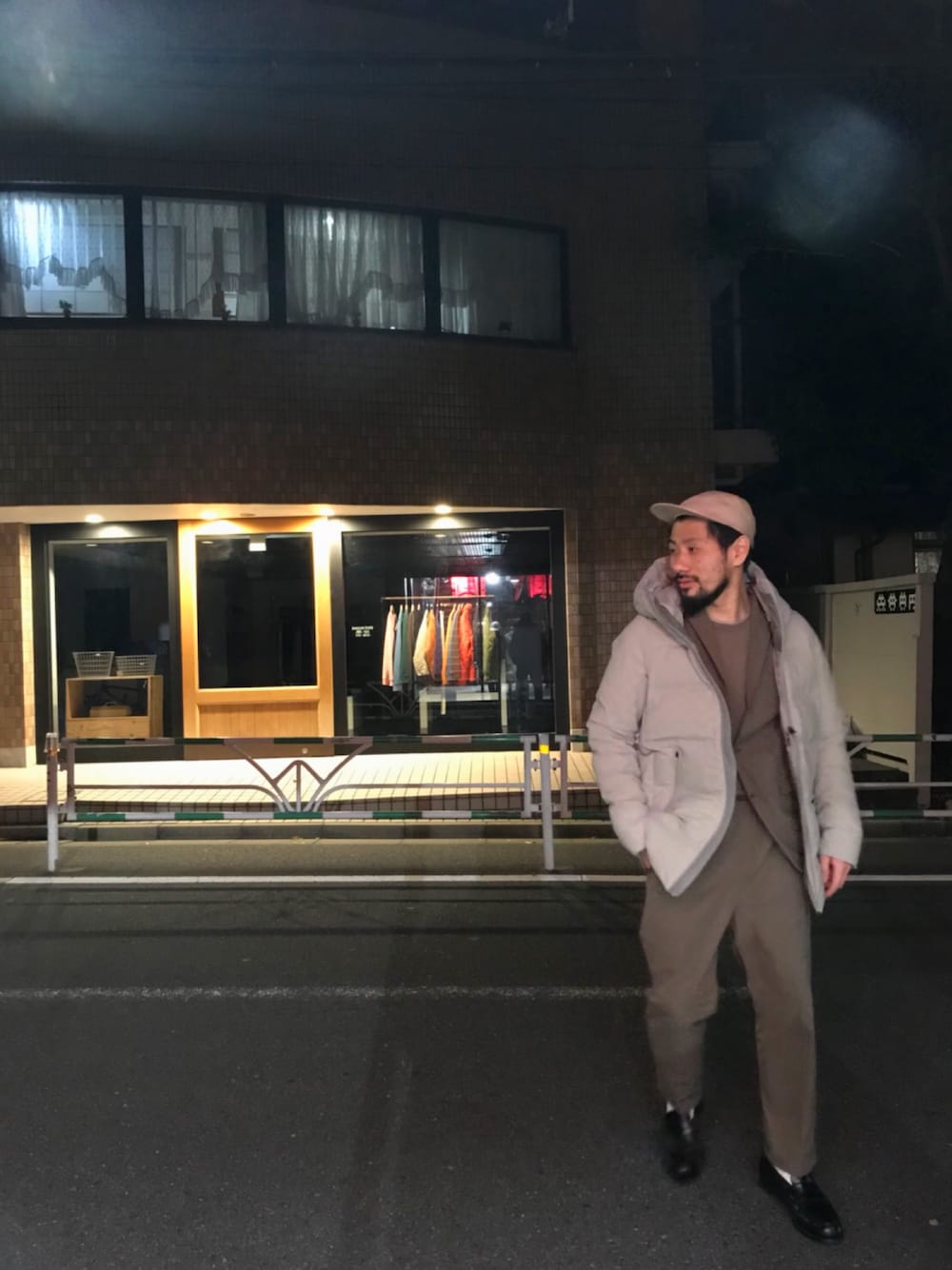 グレー系のダウンジャケット/コート、ブラウン系のスラックス、ブラウン系のテーラードジャケットを着用したメンズの秋コーディネートの1枚目の写真