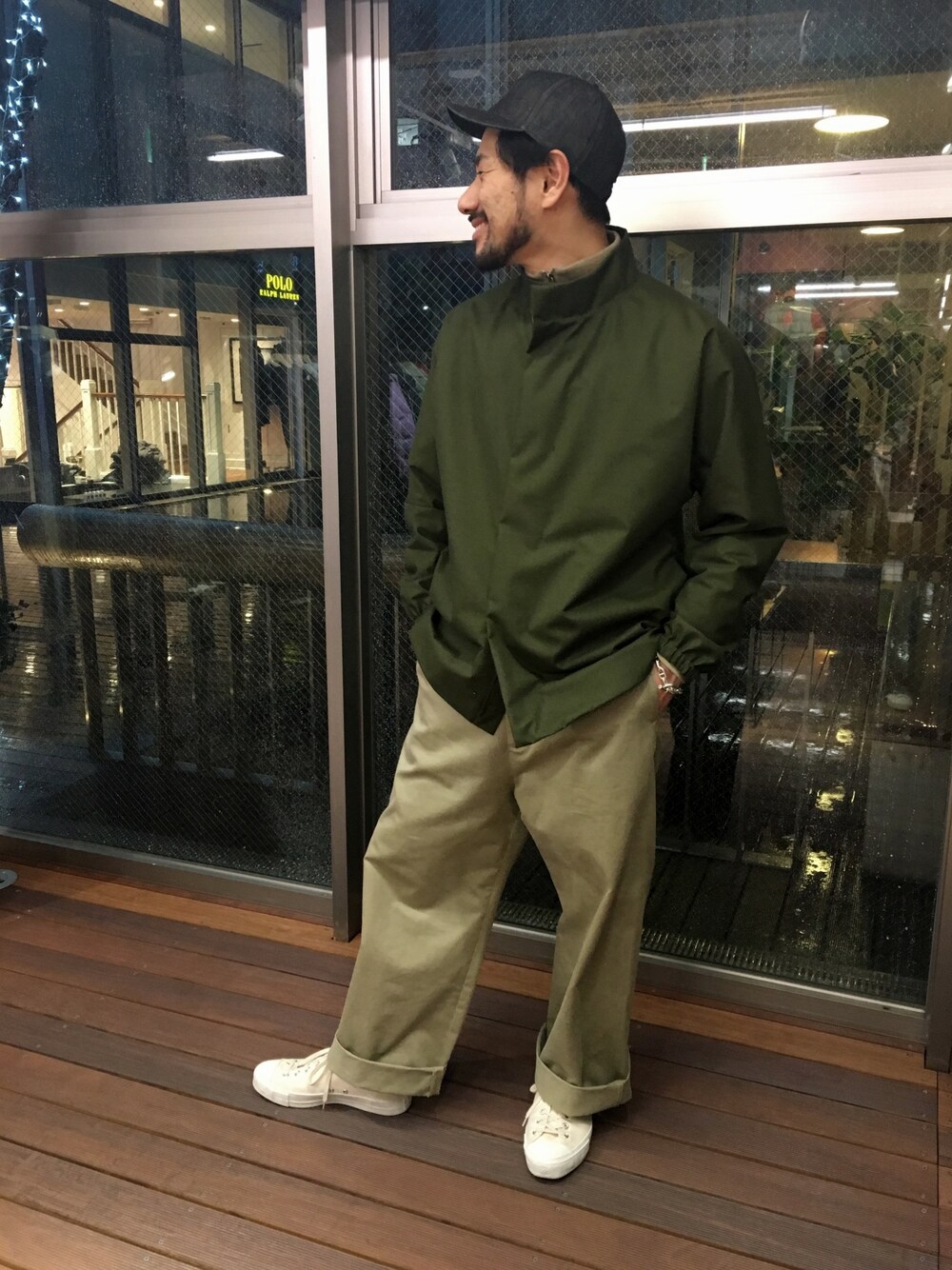 グリーン系のブルゾン、ベージュ系のパンツ、ホワイト系のスニーカーを着用したメンズの冬コーディネートの1枚目の写真