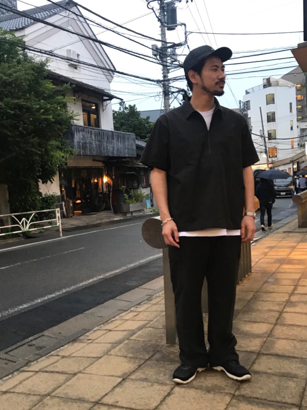 ブラック系のシャツ/ブラウス、ブラック系のカーゴパンツ、ブラック系のスニーカーを着用したメンズの春コーディネートの1枚目の写真