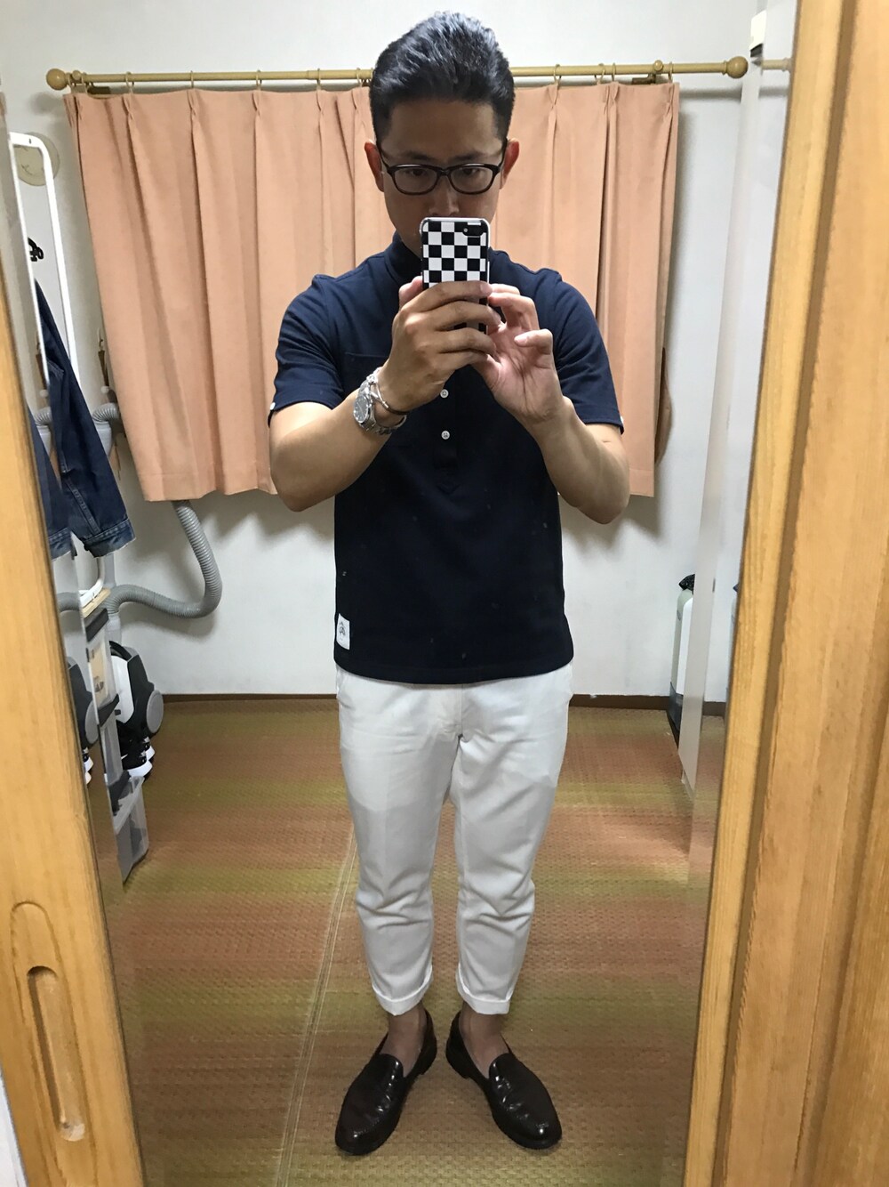 ブルー系のポロシャツ、ホワイト系のチノパンツ、ブラウン系のドレスシューズを着用したメンズの春コーディネートの1枚目の写真