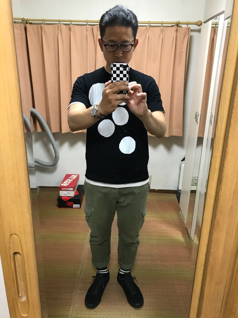 ブラック系のTシャツ/カットソー、ホワイト系のTシャツ/カットソー、グリーン系のカーゴパンツを着用したメンズの春コーディネートの1枚目の写真