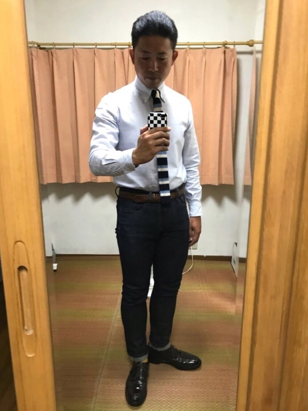 ブルー系のネクタイ、ブルー系のデニムパンツ、ブラウン系のドレスシューズを着用したメンズの秋コーディネートの1枚目の写真