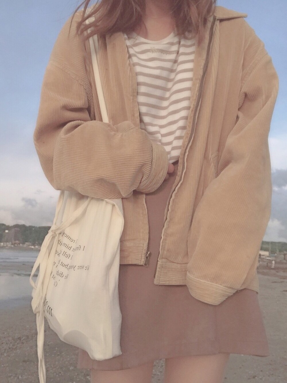 イエロー系のその他アウター、ベージュ系のスカート、ベージュ系のTシャツ/カットソーを着用したレディースの春コーディネートの1枚目の写真