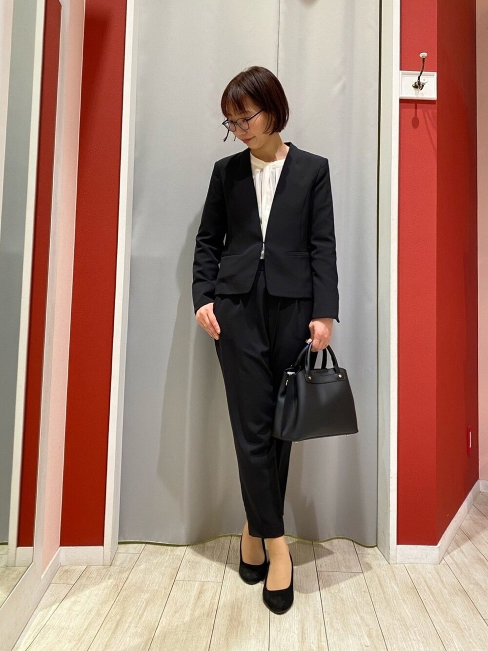 ブラック系のノーカラージャケット、ホワイト系のシャツ/ブラウス、ブラック系のその他パンツを着用したレディースの冬コーディネートの1枚目の写真