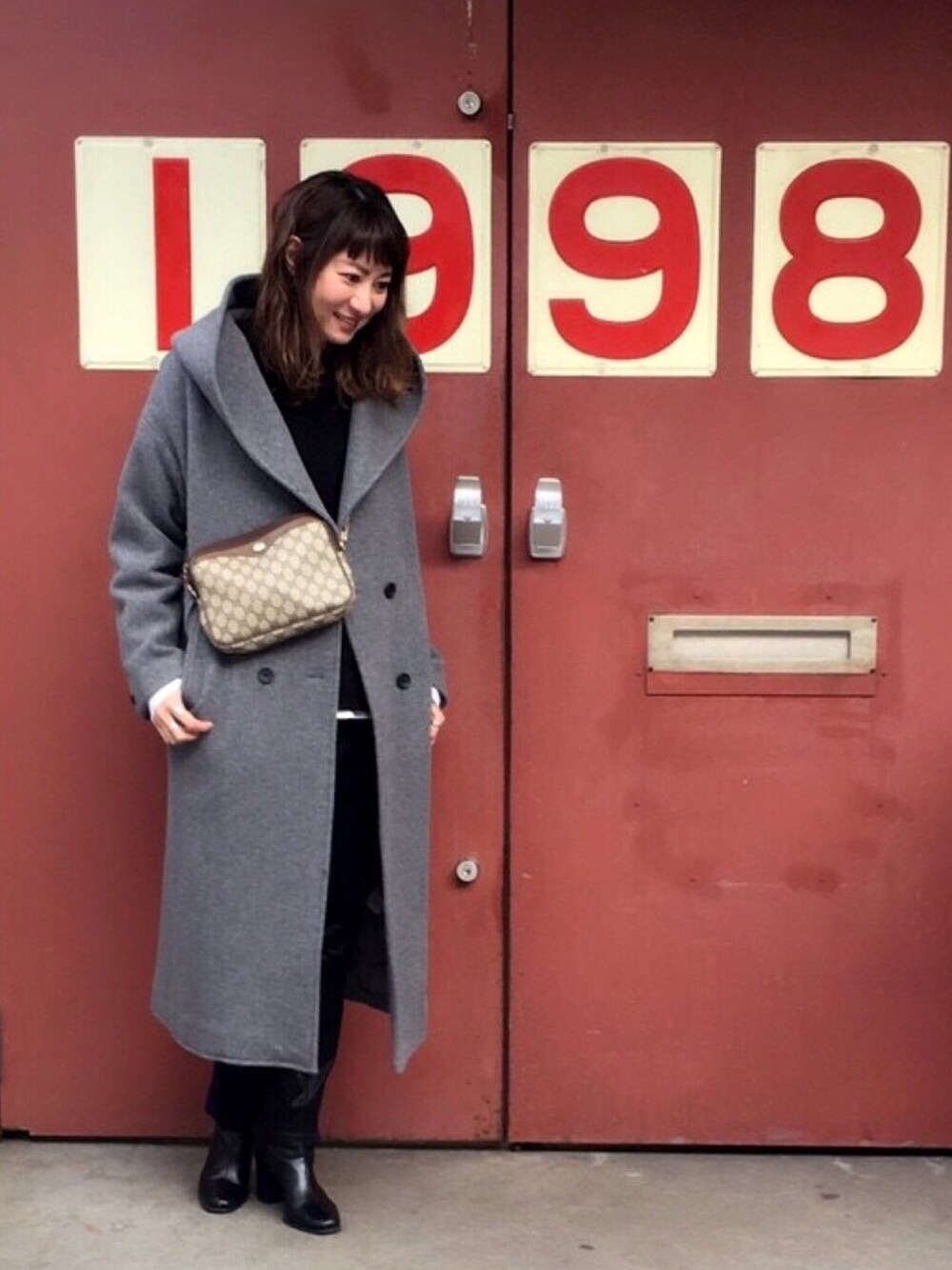 グレー系のその他アウター、ブラック系のニット/セーター、ブラック系のパンツを着用したレディースの冬コーディネートの1枚目の写真