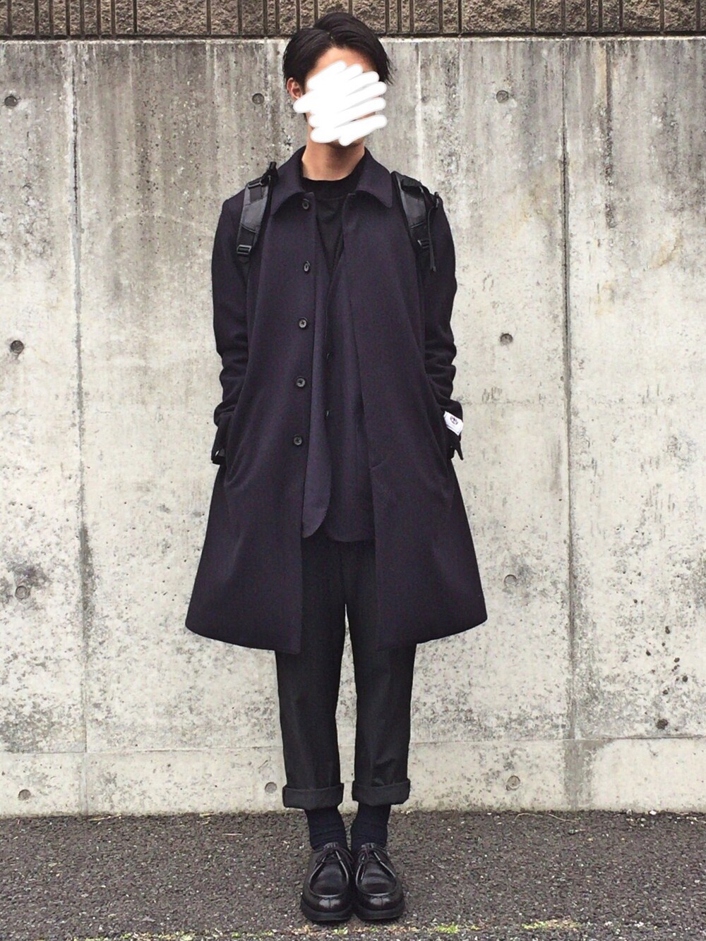 ブルー系のステンカラーコート、ブルー系のテーラードジャケット、ブラック系のバックパック/リュックを着用したメンズの冬コーディネートの1枚目の写真