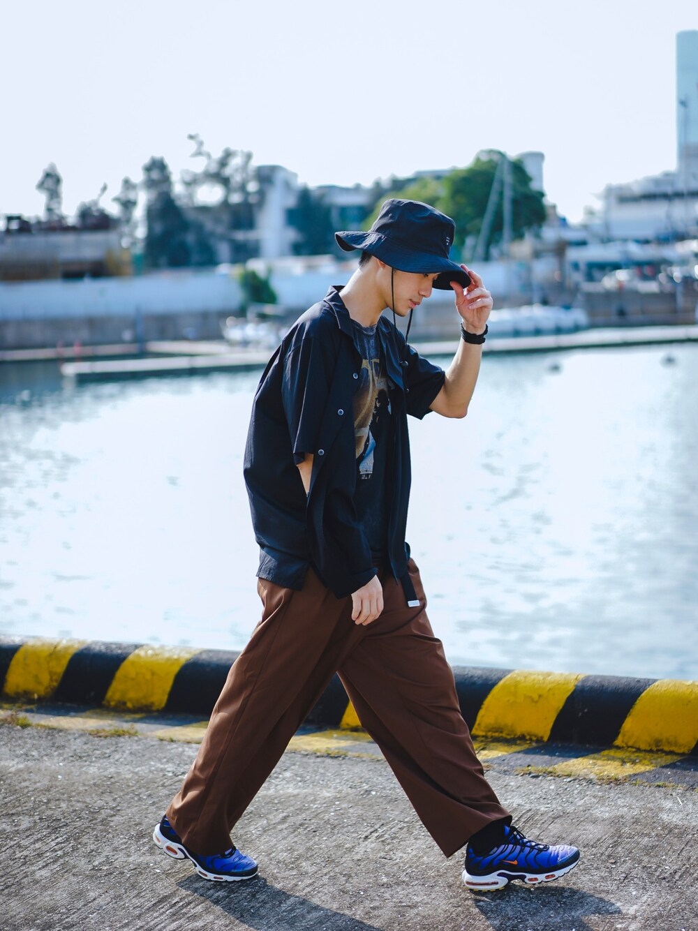 ブラック系のシャツ/ブラウス、ブラウン系のチノパンツ、パープル系のスニーカーを着用したメンズの春コーディネートの1枚目の写真