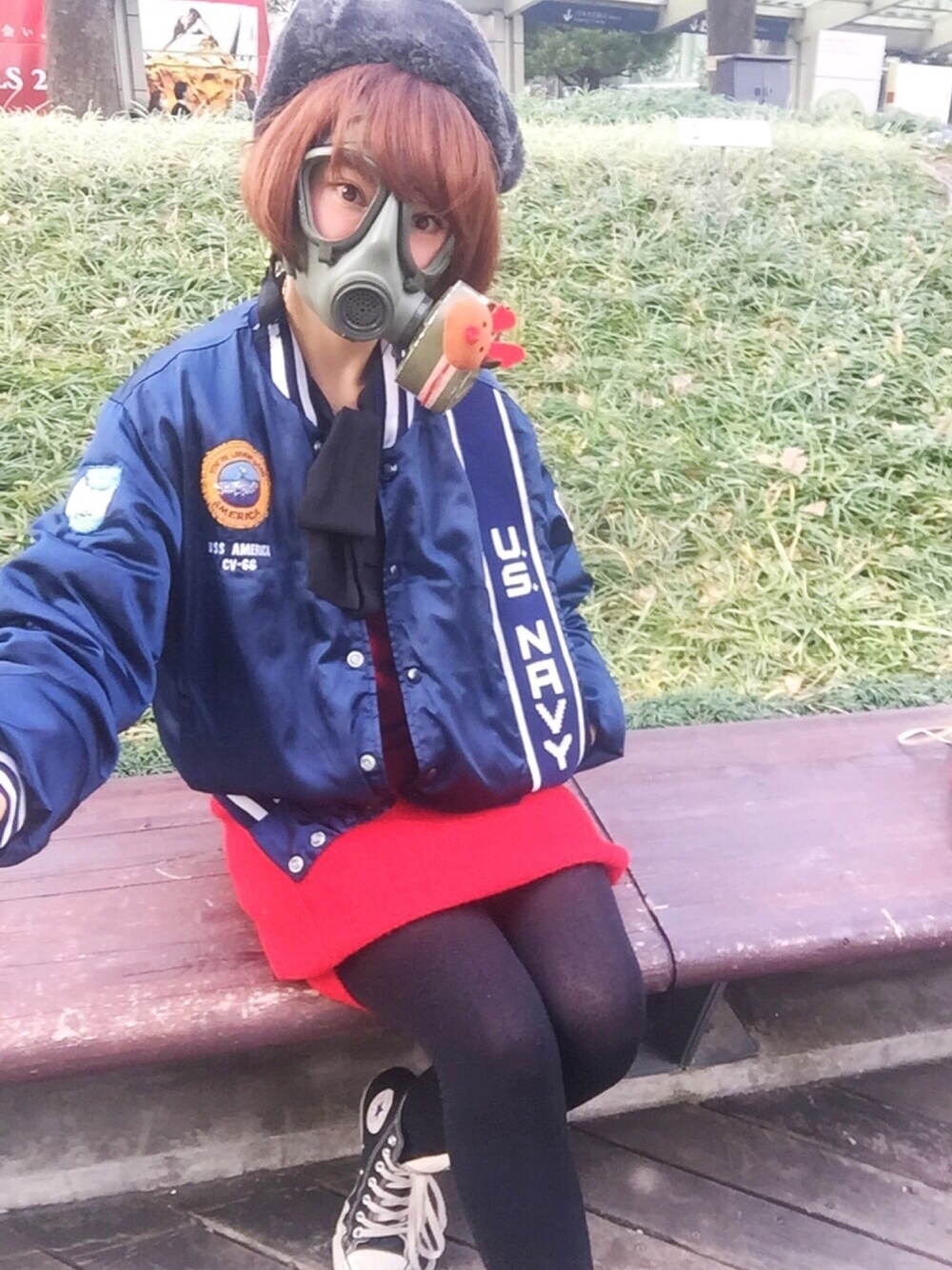 ブルー系のミリタリージャケット、ブラック系のスニーカー、レッド系のワンピースを着用したレディースの冬コーディネートの1枚目の写真