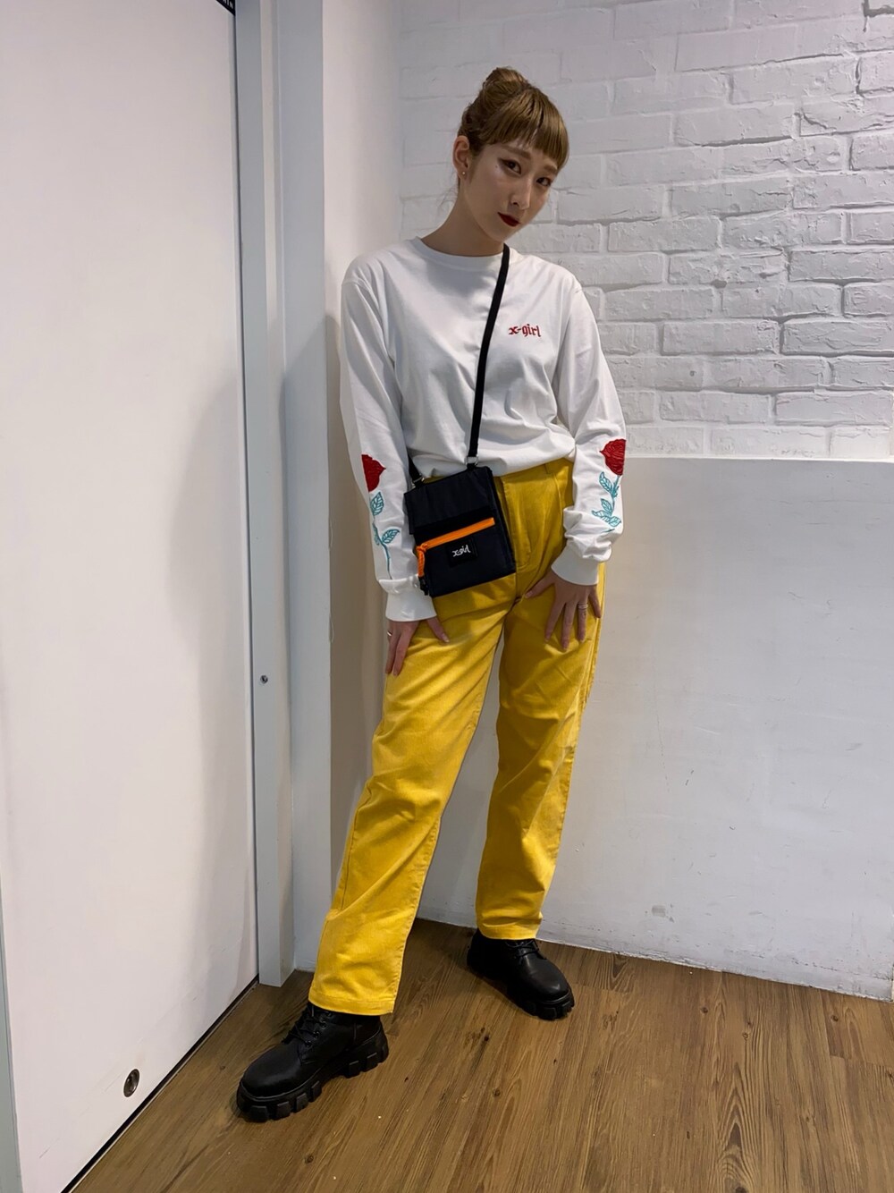 ホワイト系のTシャツ/カットソー、イエロー系のその他パンツ、ブラック系のポーチを着用したレディースの秋コーディネートの1枚目の写真