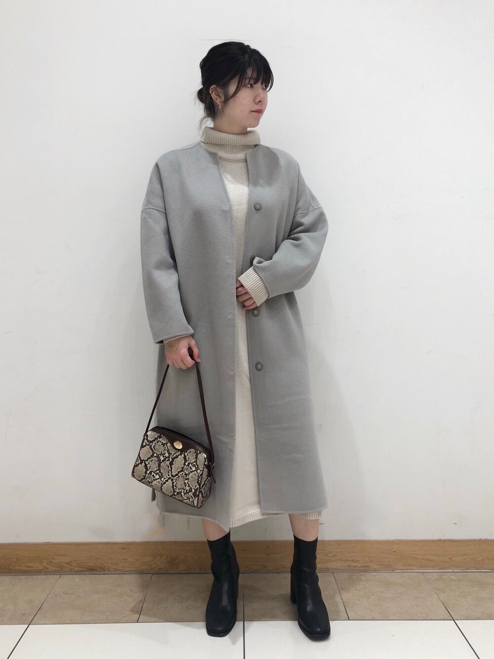 グリーン系のノーカラージャケット、ホワイト系のワンピース、その他のショルダーバッグを着用したレディースの秋コーディネートの1枚目の写真