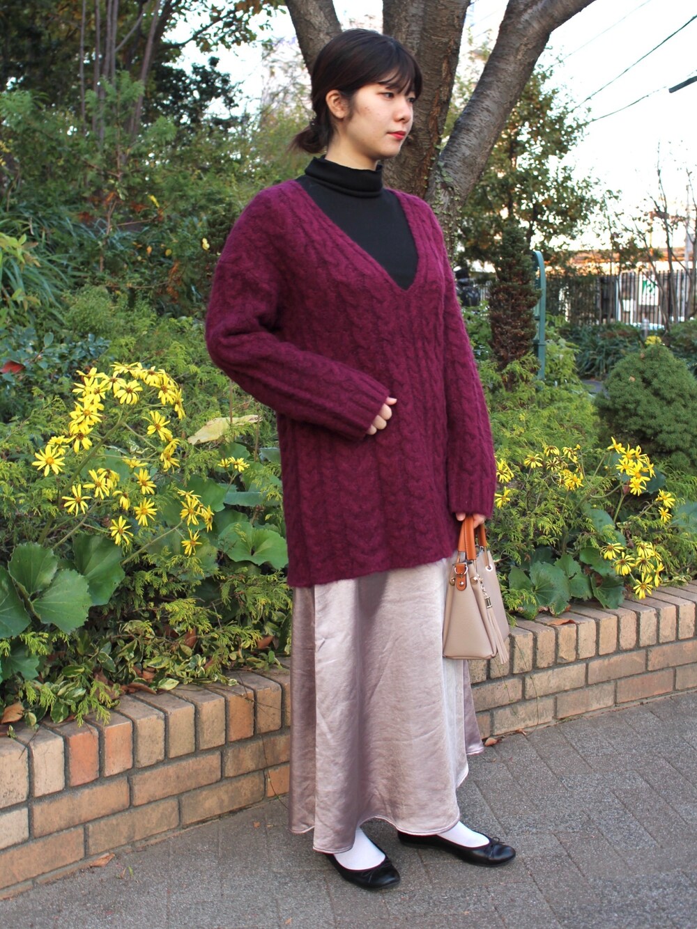 ブラック系のTシャツ/カットソー、パープル系のニット/セーター、パープル系のスカートを着用したレディースの冬コーディネートの1枚目の写真