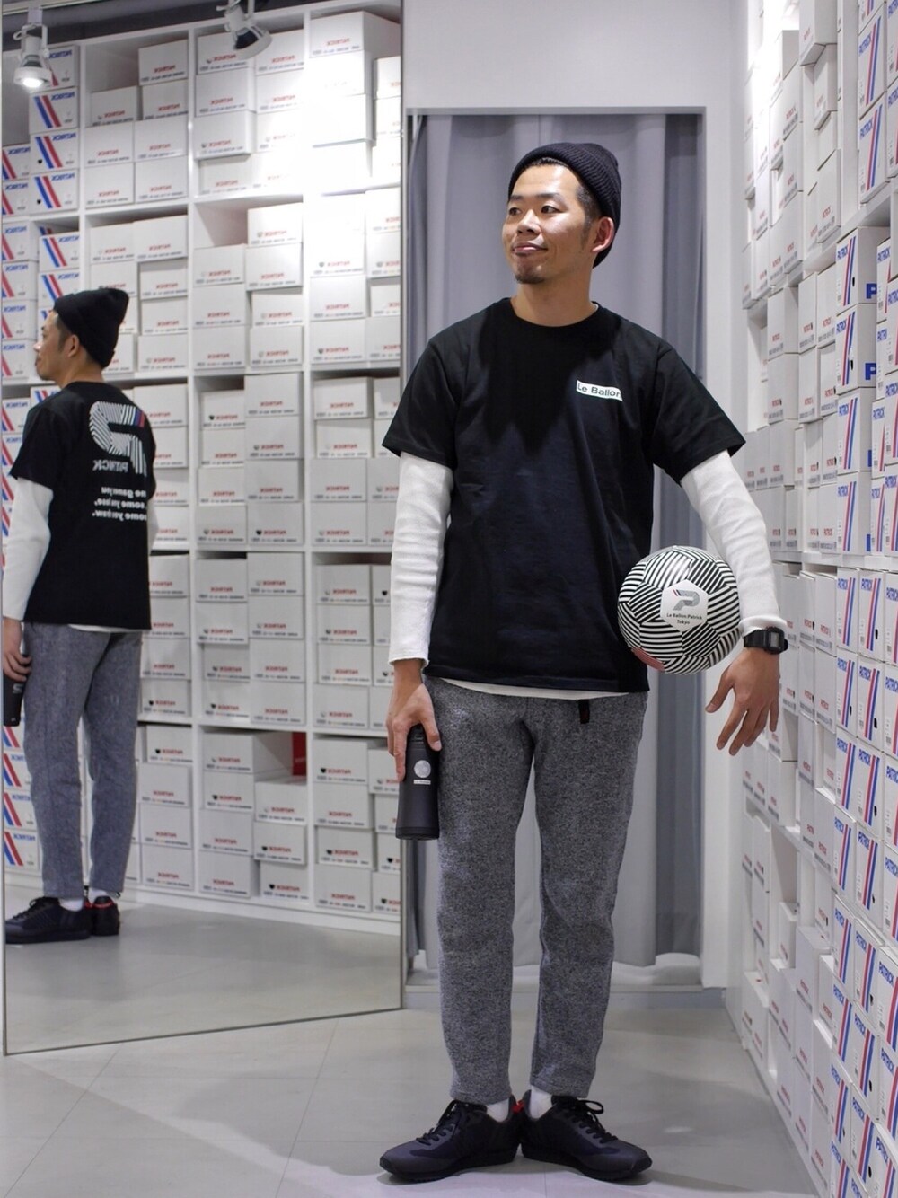 グレー系のパンツ、ブラック系のTシャツ/カットソー、ブラック系のスニーカーを着用したメンズの秋コーディネートの1枚目の写真