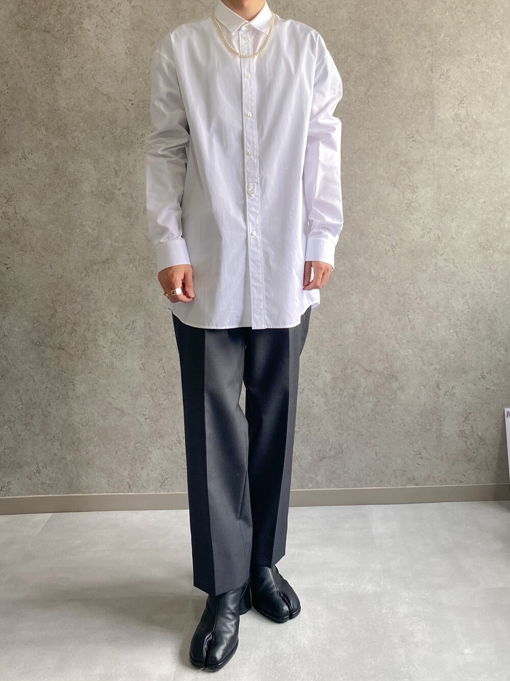 ホワイト系のシャツ/ブラウス、ブラック系のスラックス、ブラック系のブーツを着用したメンズの春コーディネートの1枚目の写真