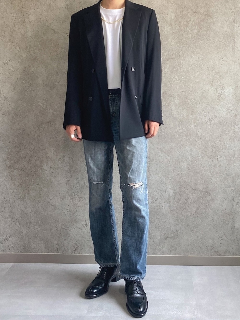 ブラック系のテーラードジャケット、ホワイト系のTシャツ/カットソー、ブルー系のデニムパンツを着用したメンズの夏コーディネートの1枚目の写真