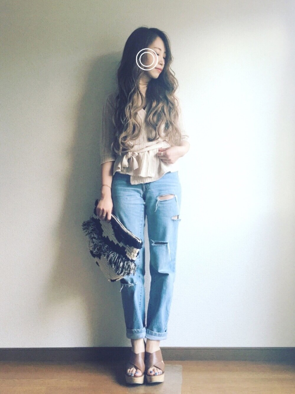 ベージュ系のニット/セーター、ホワイト系のクラッチバッグ、ブラウン系のサンダルを着用したレディースの春コーディネートの1枚目の写真