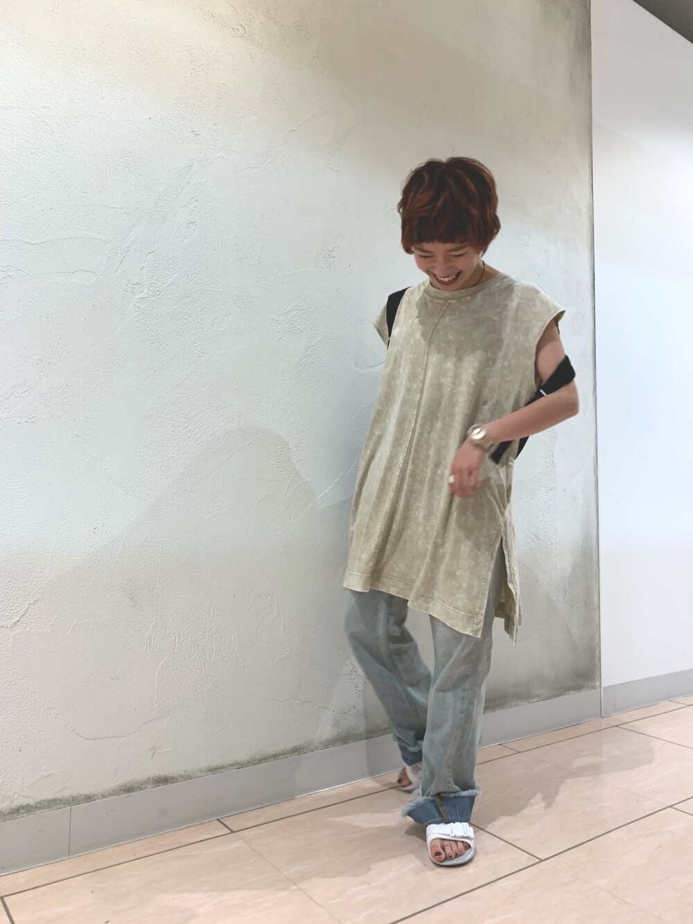 ベージュ系のTシャツ/カットソー、ブルー系のデニムパンツ、ホワイト系のサンダルを着用したレディースの夏コーディネートの1枚目の写真