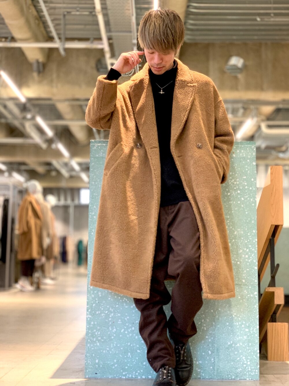 ブラック系のニット/セーター、イエロー系のチェスターコート、グレー系のその他パンツを着用したメンズの冬コーディネートの1枚目の写真