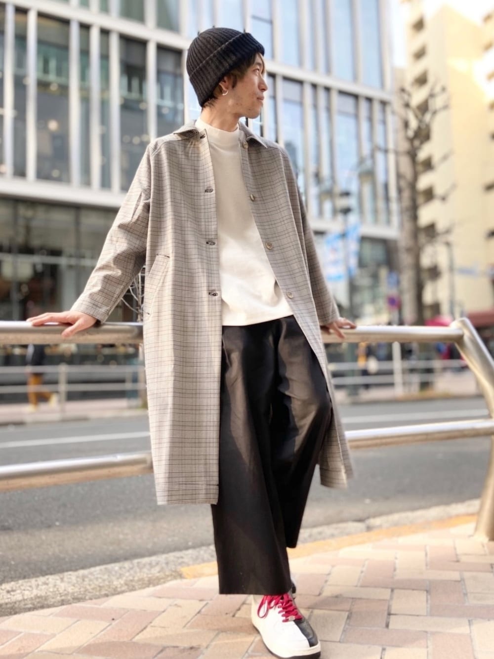 ブラック系のステンカラーコート、ホワイト系のTシャツ/カットソー、ブラック系のその他パンツを着用したメンズの春コーディネートの1枚目の写真