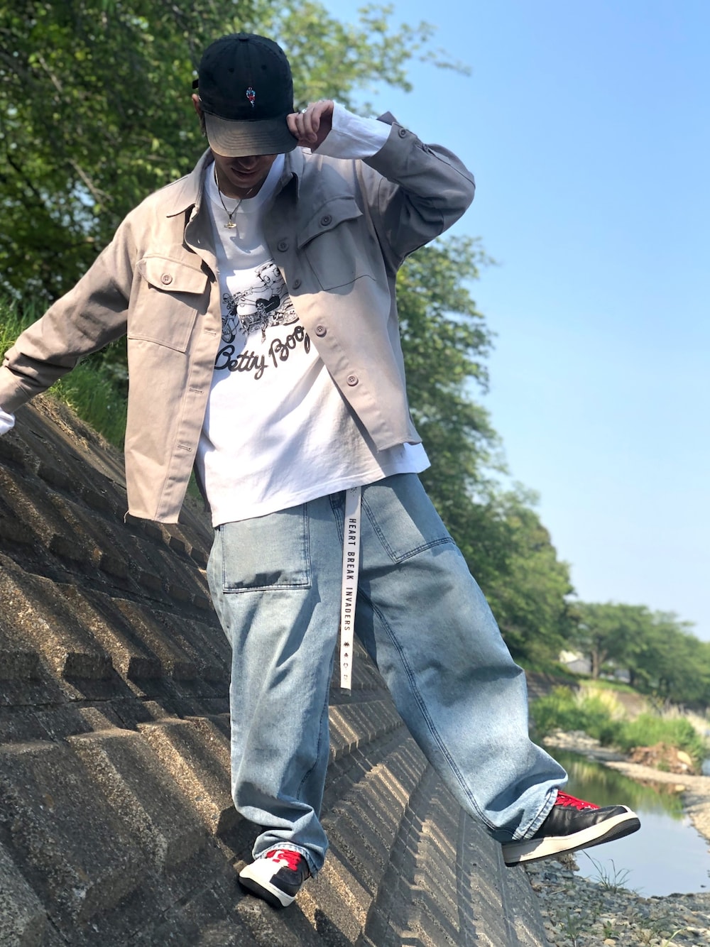 グレー系のブルゾン、ホワイト系のTシャツ/カットソー、ブラック系のスニーカーを着用したメンズの春コーディネートの1枚目の写真