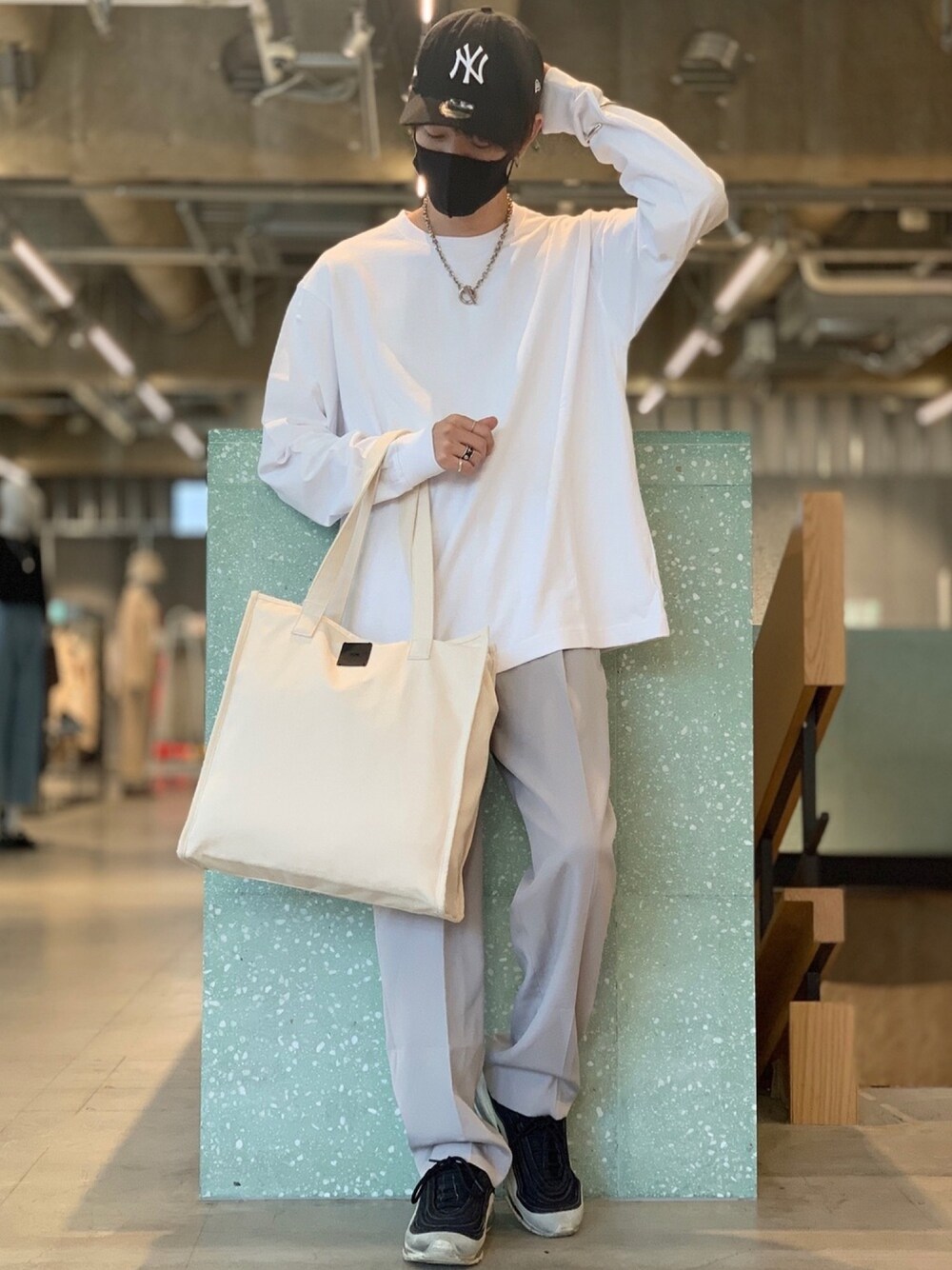 ホワイト系のTシャツ/カットソー、グレー系のスラックス、ホワイト系のトートバッグを着用したメンズの夏コーディネートの1枚目の写真