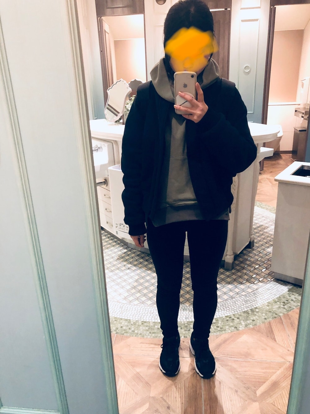 ブルー系のブルゾン、グリーン系のパーカー、ブラック系のスニーカーを着用したレディースの冬コーディネートの1枚目の写真