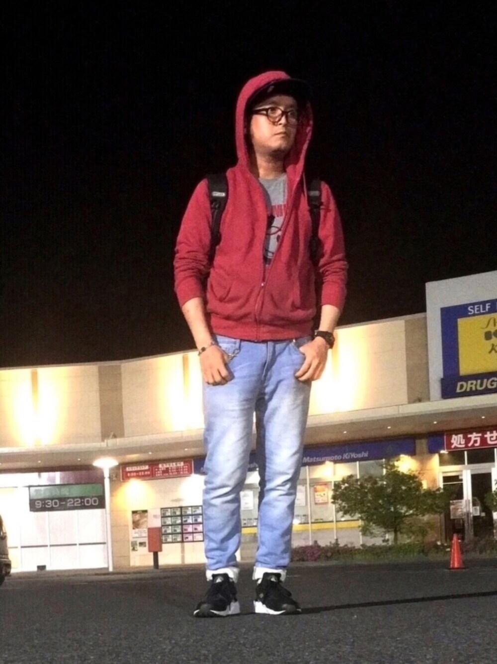 レッド系のパーカー、グレー系のTシャツ/カットソー、ブルー系のメッセンジャーバッグを着用したメンズの春コーディネートの1枚目の写真