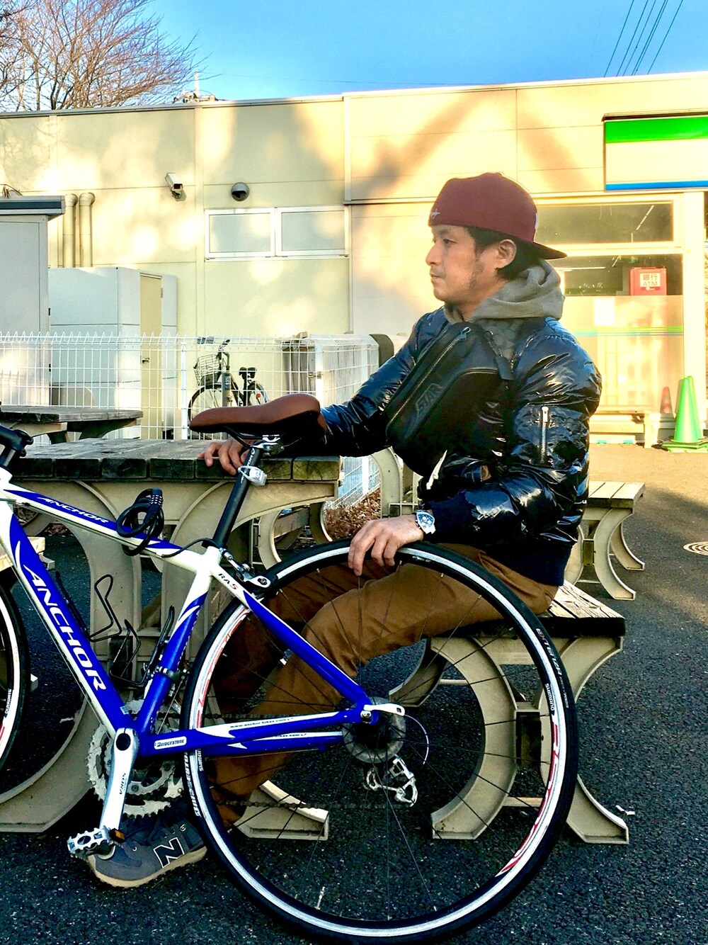 グレー系のスニーカー、ブラック系のボディバッグ/ウエストポーチ、ブルー系のダウンジャケット/コートを着用したメンズの冬コーディネートの1枚目の写真