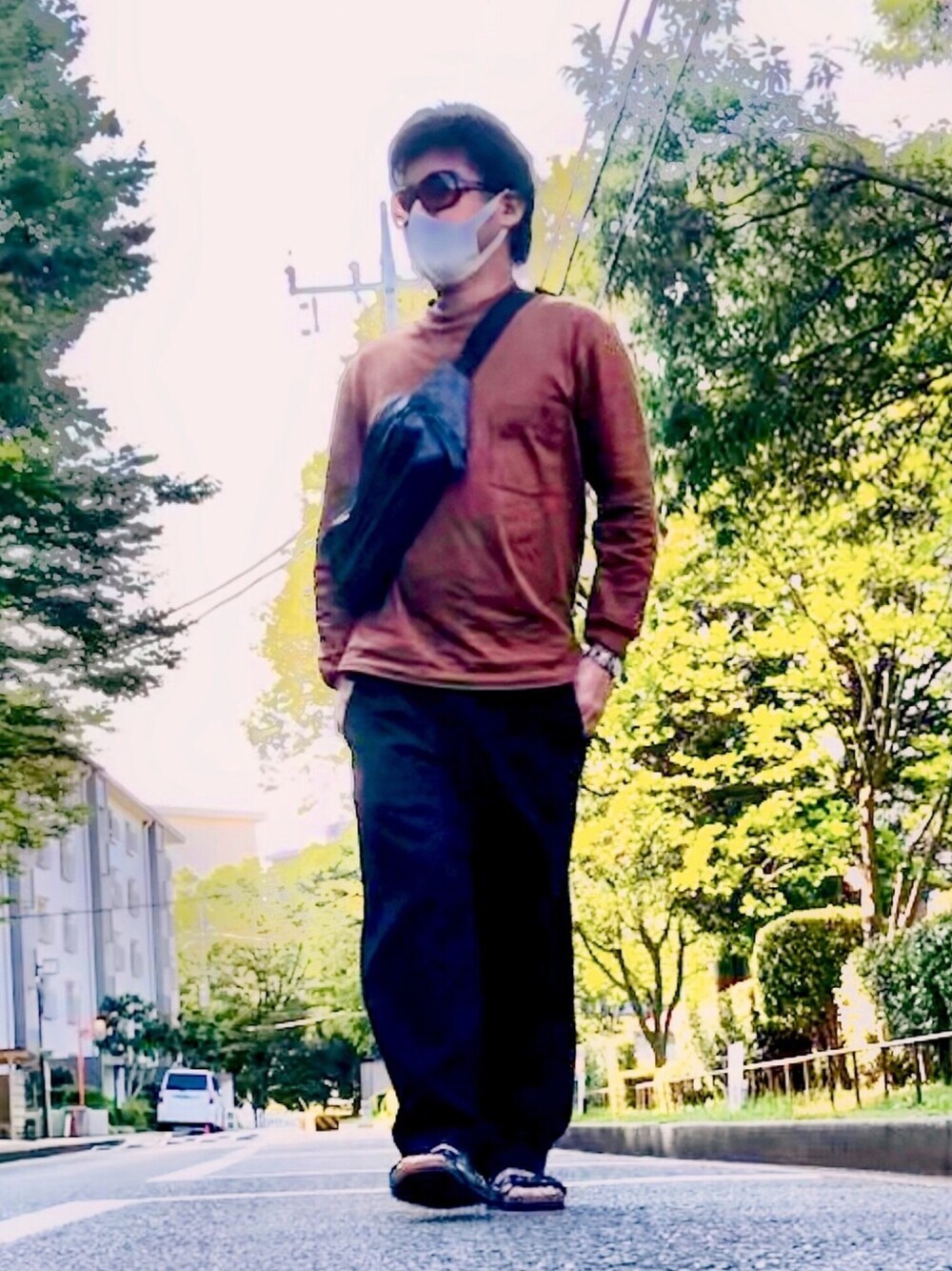 ブラウン系のTシャツ/カットソー、ブラック系のボディバッグ/ウエストポーチ、ブラック系のパンツを着用したメンズの夏コーディネートの1枚目の写真