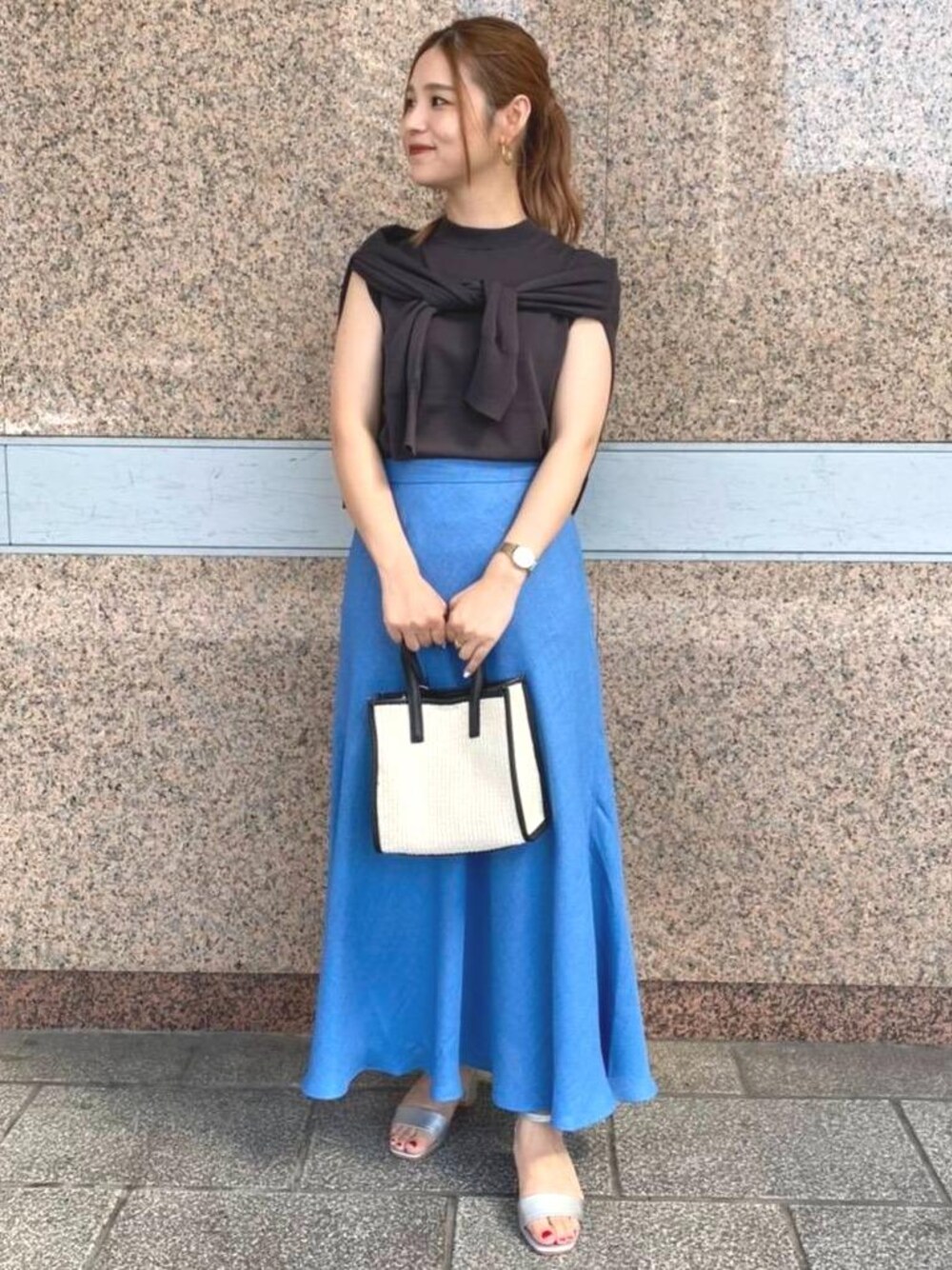 シルバー系のサンダル、グレー系のカーディガン/ボレロ、ブルー系のスカートを着用したレディースの夏コーディネートの1枚目の写真