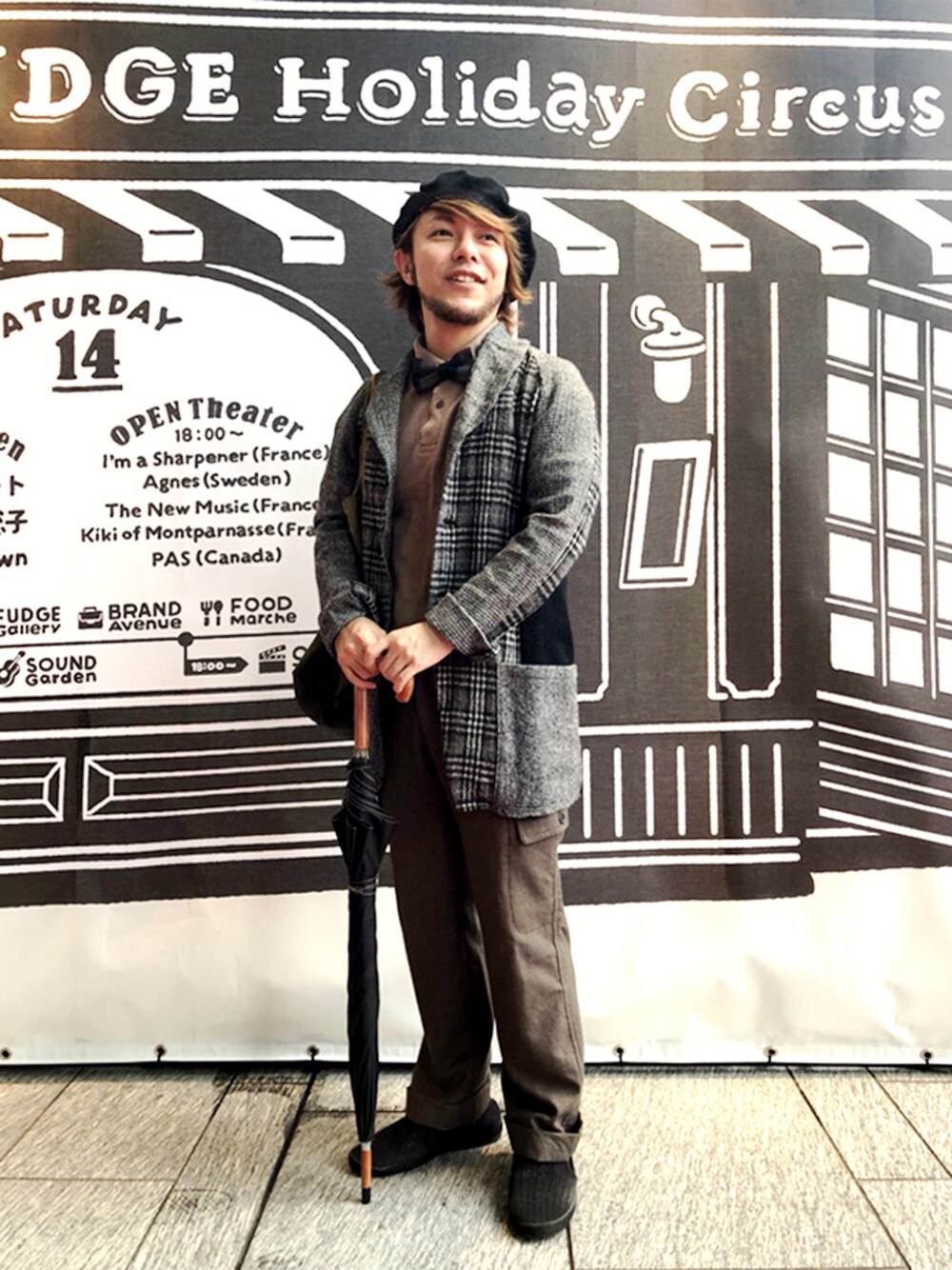 ブルー系の蝶ネクタイ、ブラウン系のポロシャツ、グレー系のその他アウターを着用したメンズの秋コーディネートの1枚目の写真